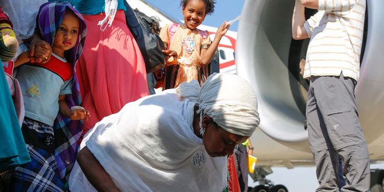 Ethiopian woman praying on the ground after just making Aliyah.