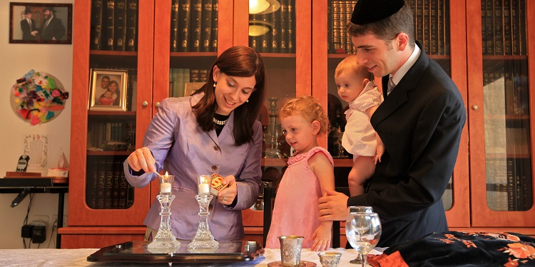 Mother of a family lighting Sabbath candles.