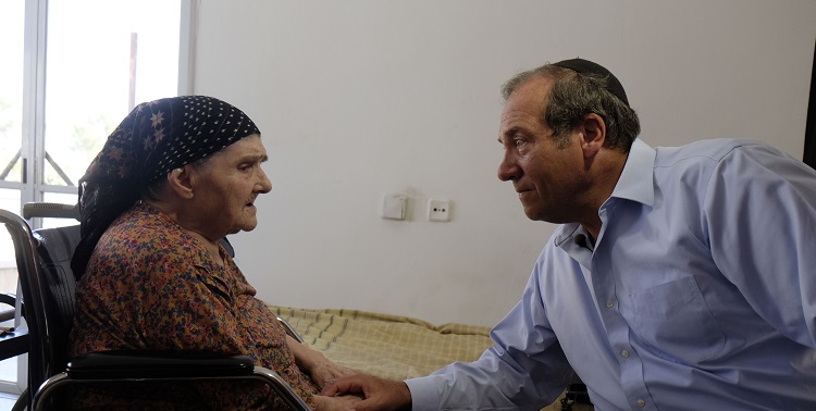 Rabbi Eckstein talking to an elderly Jewish woman in a wheelchair.