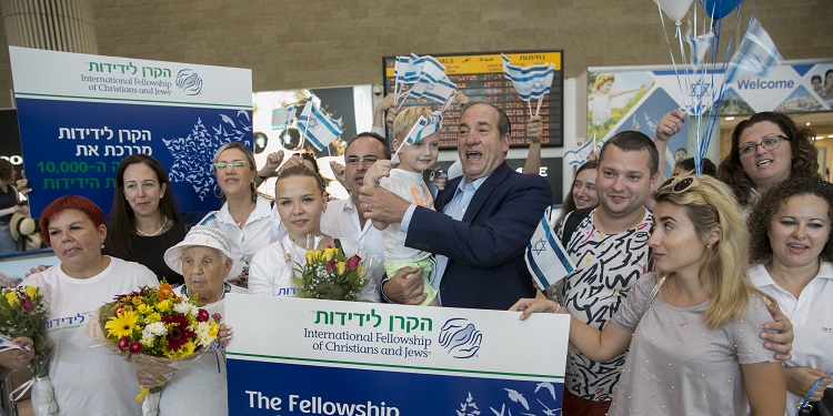 Rabbi Yechiel Eckstein with people who came on a Freedom Flight holding Israeli flags.