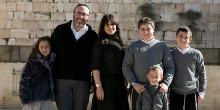 Jewish family of six standing together at the Western Wall
