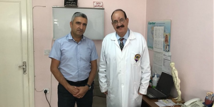 Two men standing together at a lcinic for Iraqui Christian refugees.