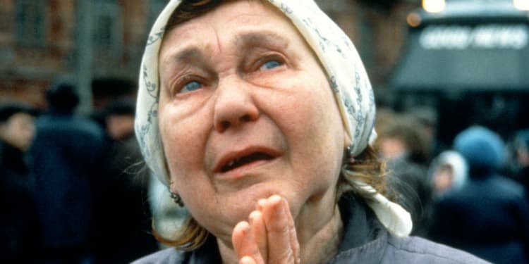 Elderly Jewish woman praying while looking up into the sky.