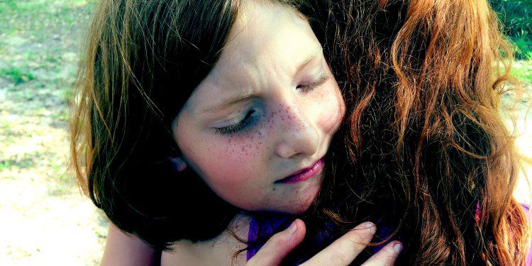 Two young girls hugging.