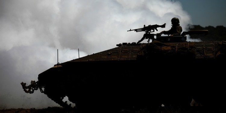 Low lit image of a soldier on a tank.