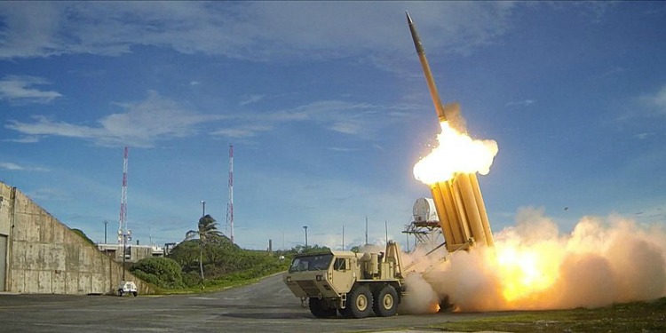 Rocket taking off into the air off the back of a military truck.