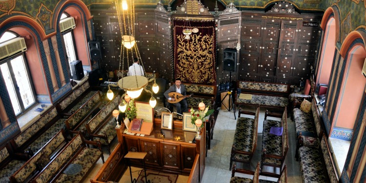 The interior of a synagogue with two men in the pews.