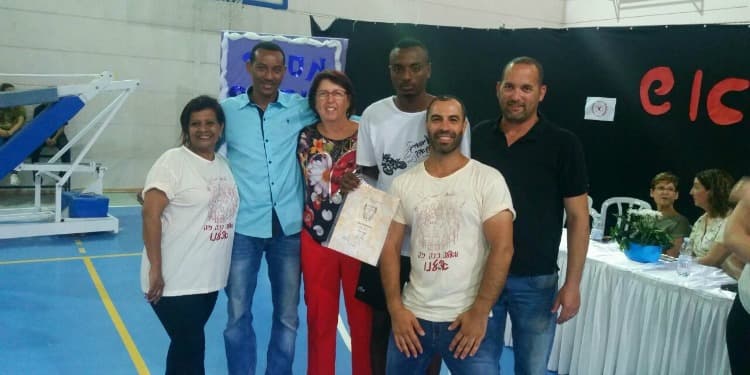 Six adults standing together smiling.