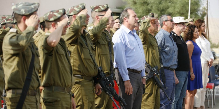 Rabbi Eckstein standing in line with four civilians and several soldiers who are saluting.