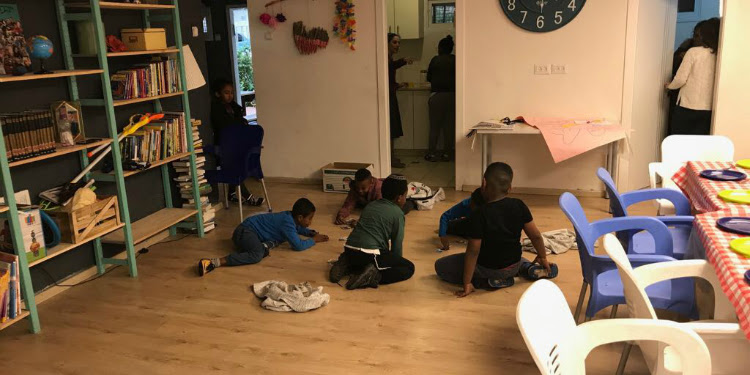Six children playing together on the floor.