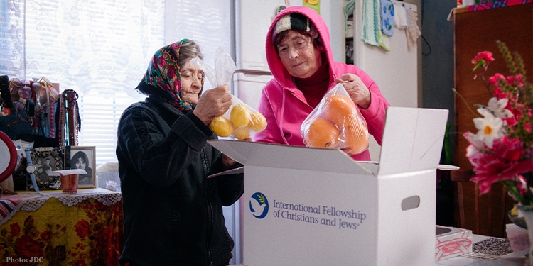 Elderly women stand in kitchen unpack branded logo food box