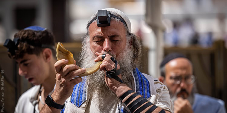 An orthodox Jewish man blowing a shofar