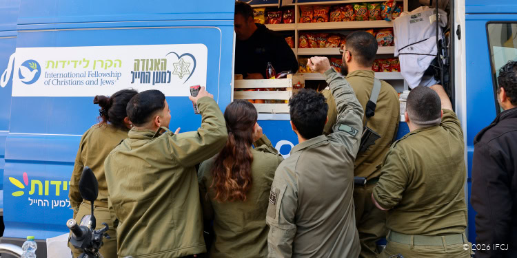 Relief workers distribute food to people in need from a mobile aid truck.