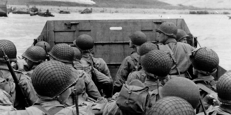 Black and white image of soldiers in the back of a truck.