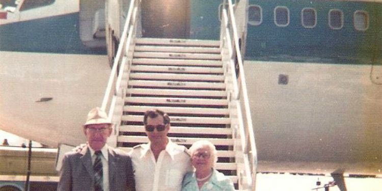Dated image of three people standing in front of a plane.