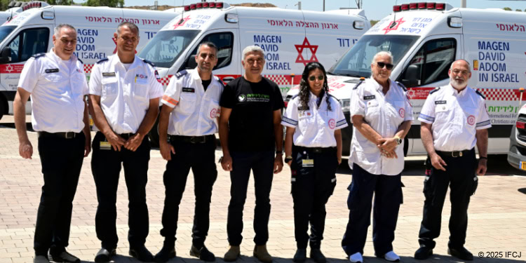 A group of people standing next to each other in front of some white vans.