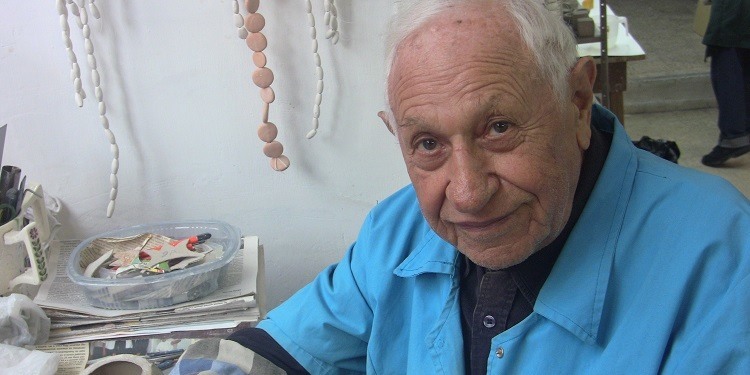 Elderly Jewish man in blue looking directly into the camera.
