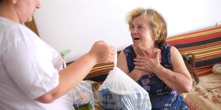 IFCJ volunteer bringing hot meals to a recipient.