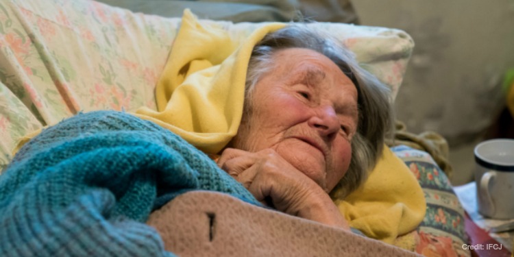 A bedbound elderly Jewish woman with several heavy blankets over her.