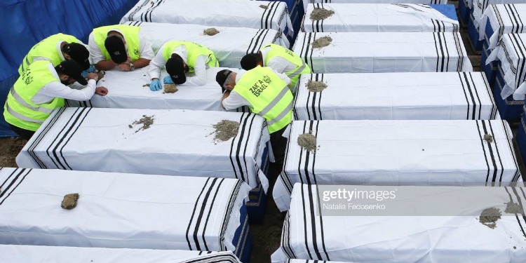 Six men praying over a coffin.