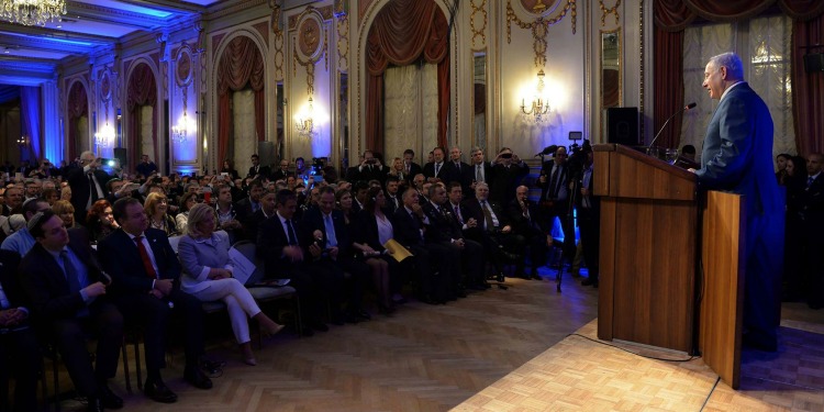 Bibi giving a speech at a podium in Buenos Aires
