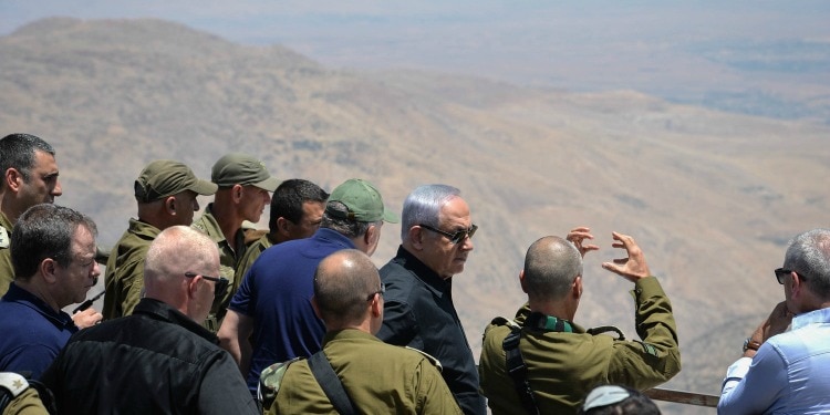 Bibi standing overhead a mountain with a group of soldiers.