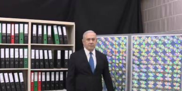 Bibi standing in a room next to a bookshelf of binders and CDs on display.