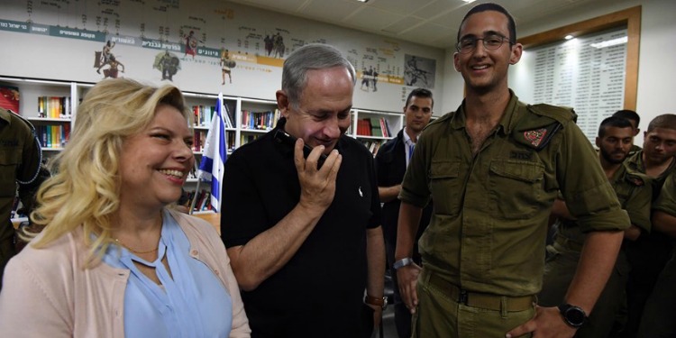 Bibi and his wife standing with a lone soldier.
