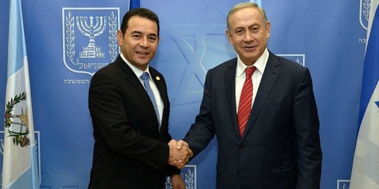 Bibi shaking hands with a man in a suit.