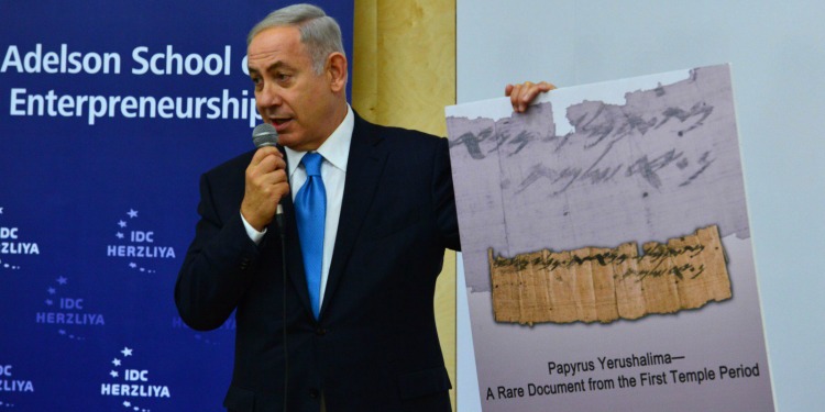 Bibi holding a sign with a picture of a document and text that reads 