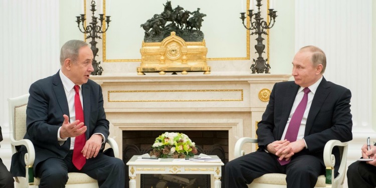 Presidents Bibi and Putin sitting together in a white and gold room.