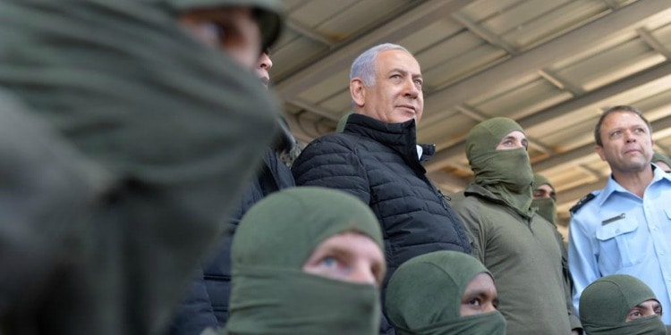 Bibi standing with soldiers in green outfits.