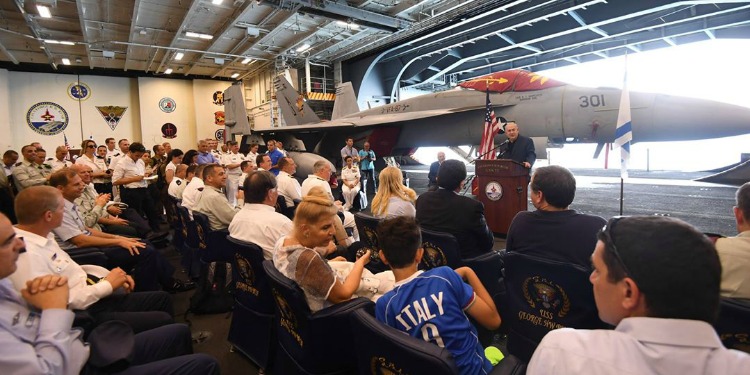 Bibi giving a speech in front of a large fighter jet.