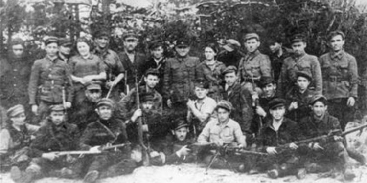 Black and white photo of young soldiers holding weapons while looking into the camera.