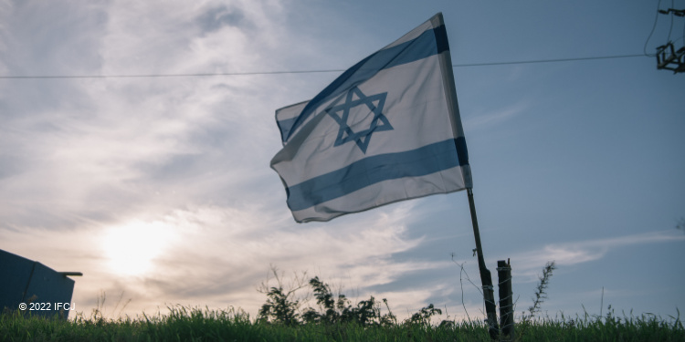 Israeli flag in the middle of a field.