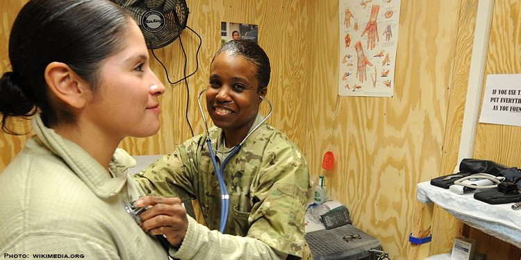 Medical soldier giving another solider a check up.