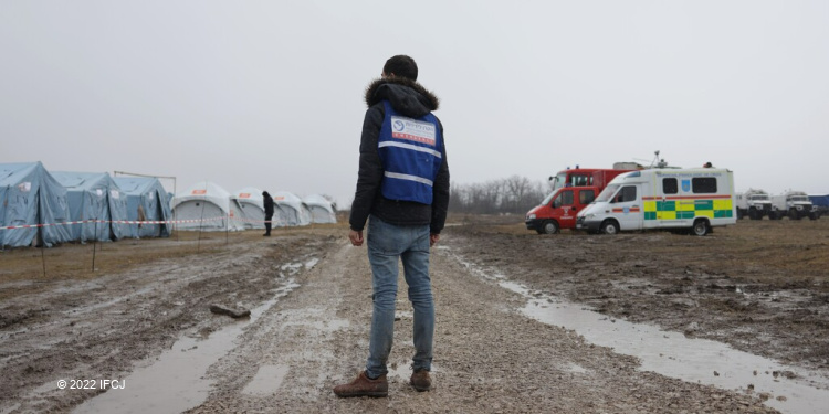 A hero stands at border crossing of Ukraine at refugee camp
