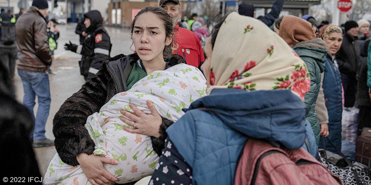 Ukrainian woman holding baby crossing border into Moldova