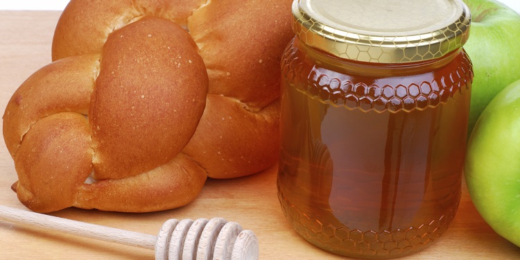A loaf of bread next to a jar of honey for Rosh Hashanah