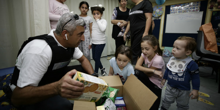 A man bringing snacks to kids in Netivot bomb shelters.
