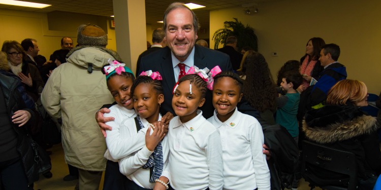 Rabbi Eckstein smiling together to four young African American girls.