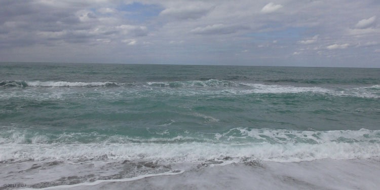 Waves rolling in from the ocean on a cloudy day.