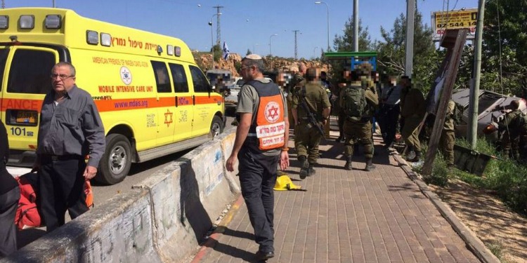 IDF soldiers and medics walking around the scene of a car ramming.