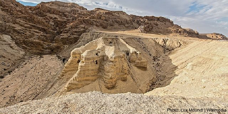 Desert landscape with cave openings in one of the hills.