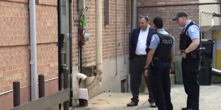 Two police officers with a man in a kippah outside a Synagogue.