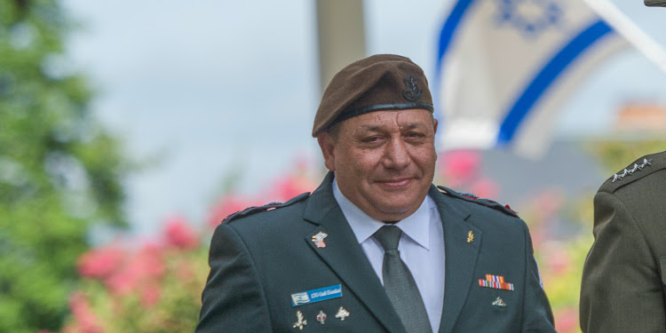 A chief in his formal attire smiling into the crowd.