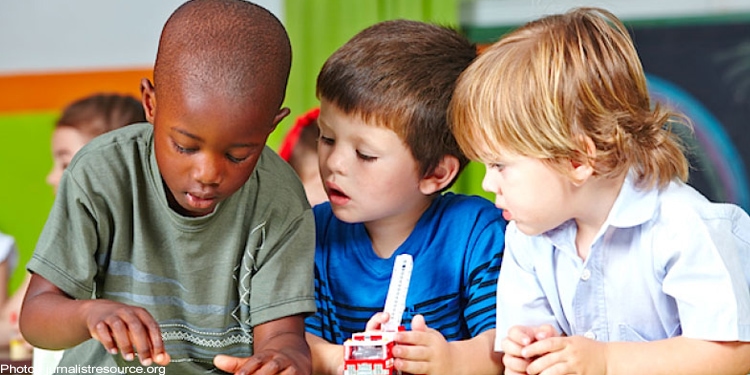 Three children sitting at a table doing an assignment