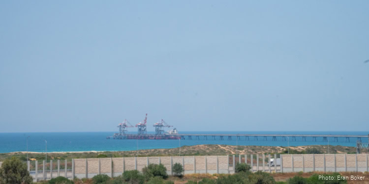 Oil platform in the Strait of Hormuz with a ship nearby, under a clear sky, illustrating maritime activity in the region.