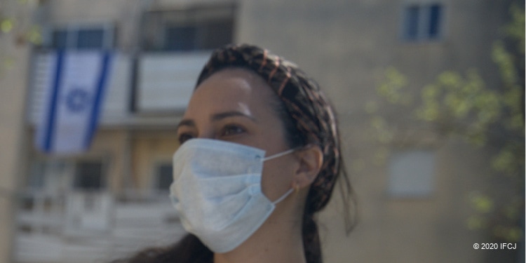 Yael Eckstein wears mask in new world of pandemic, with Israeli flag in background