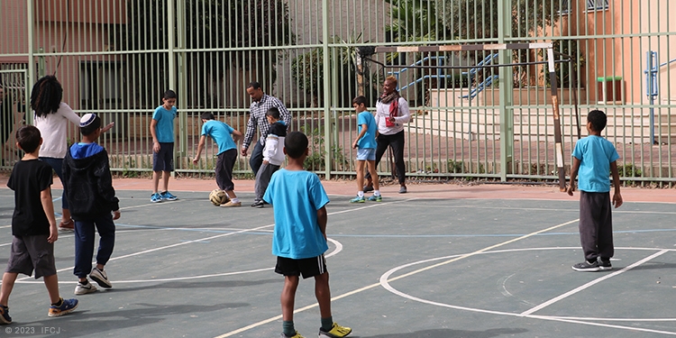 Children playing soccer on a court